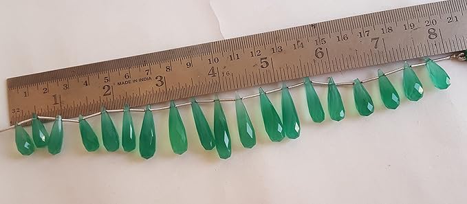 A ruler measures the green chalcedony briolette gemstone.
