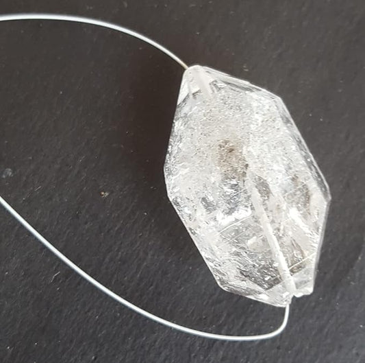 Herkimer Diamond rough gemstone bead with a centre-drilled hole arranged on a black background