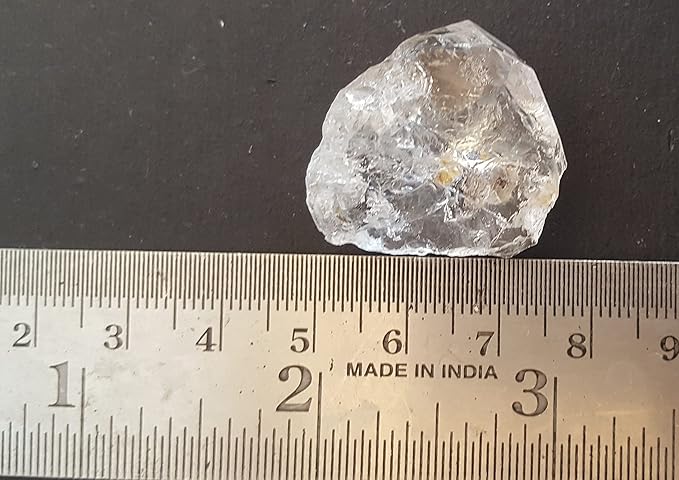 A ruler beside a herkimer diamond rough natural gemstone bead, showcasing the colour and size.