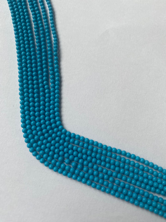 Strands of Smooth Round Howlite Turquoise beads, ranging 2.3mm in size, showcasing their vibrant colour and shine.