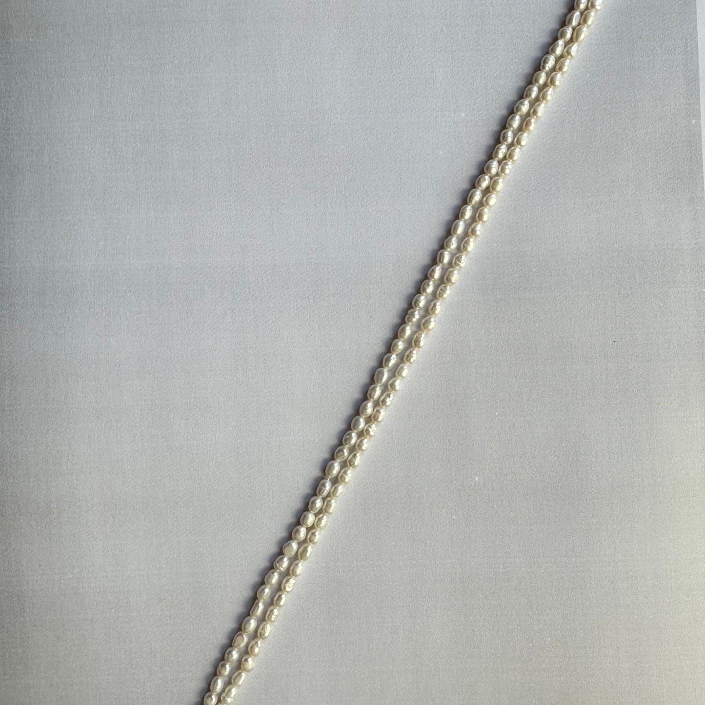 Close-up of freshwater pearl smooth rice beads, highlighting their polished finish and creamy white tones.