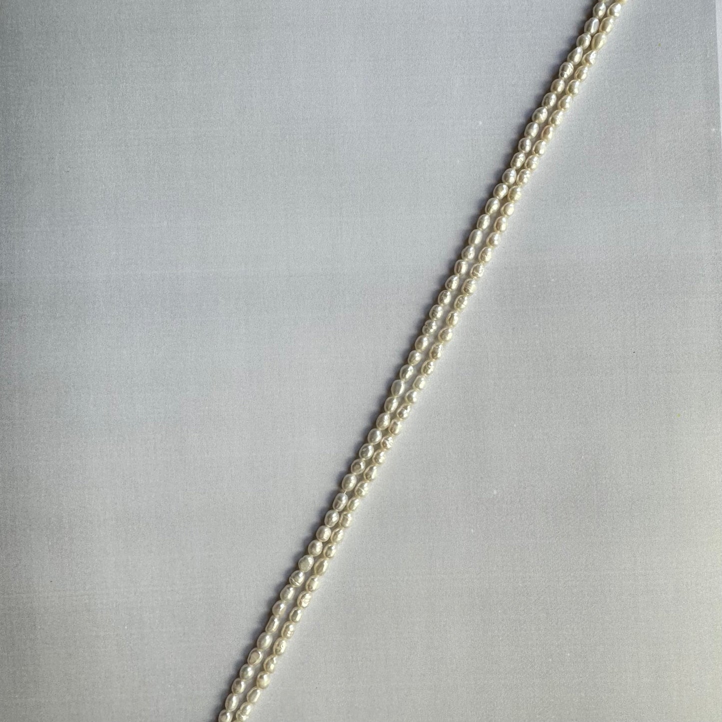 Freshwater pearls arranged in a strand, displaying their uniform shape and natural glow.
