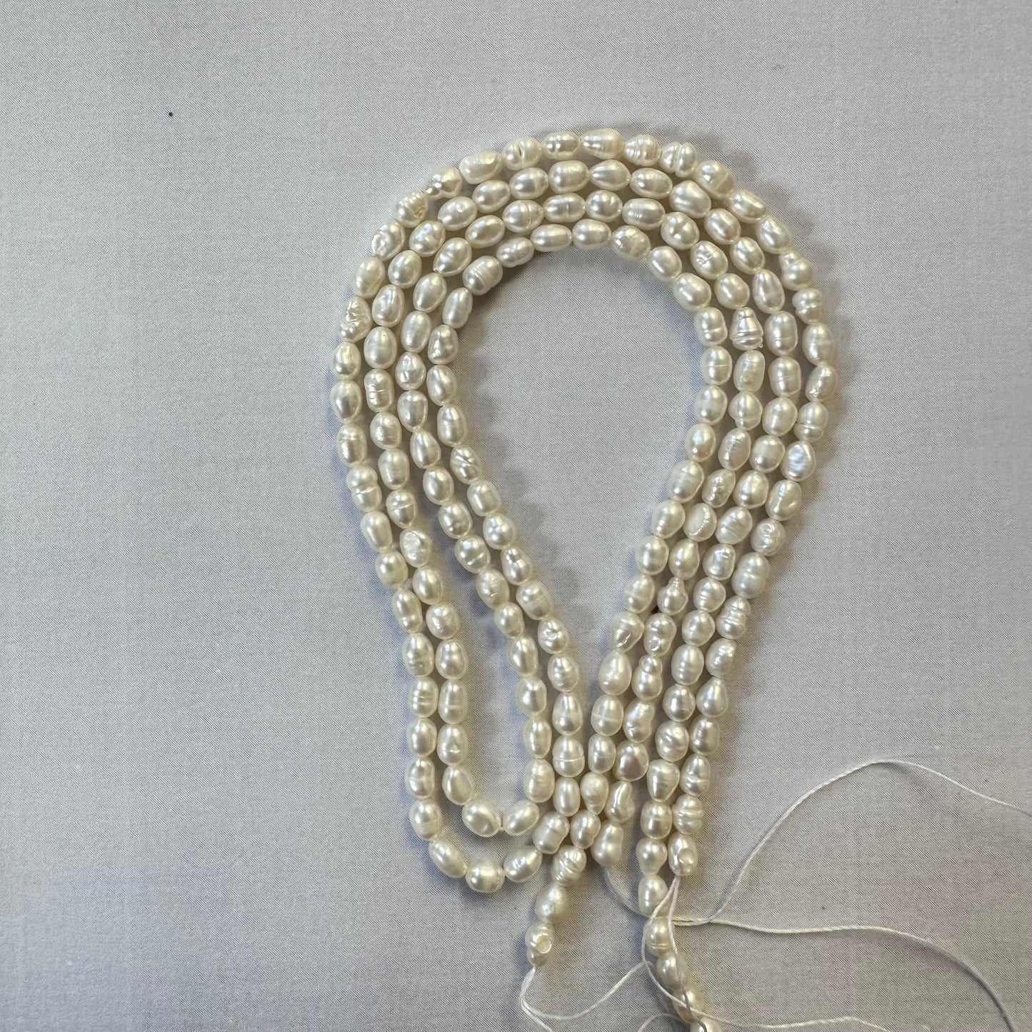 Uncut freshwater pearl strands coiled together, emphasising their soft hues and versatility in jewellery designs.