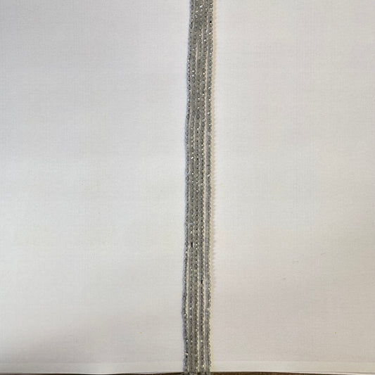 A jewellery artist arranges Labradorite beads, creating a refined gemstone piece with balanced proportions.