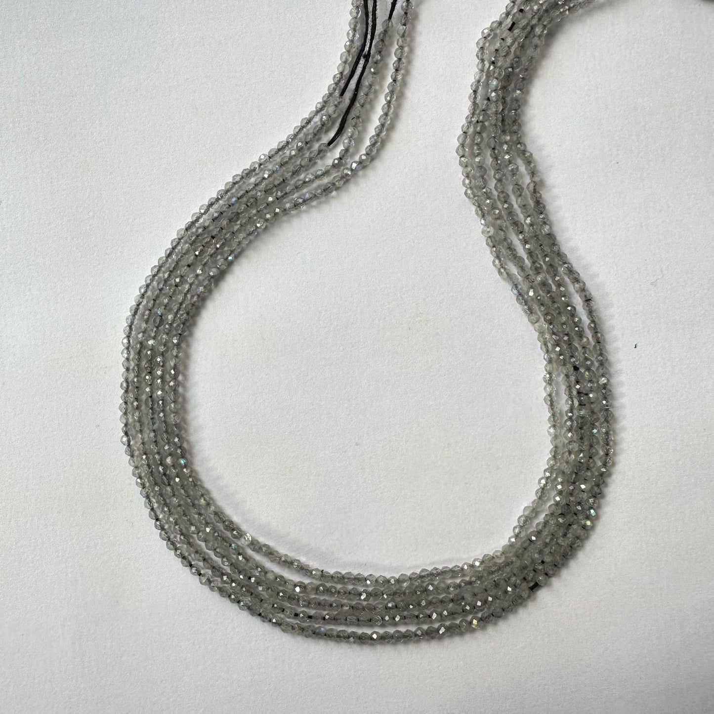 Close-up of Labradorite gemstone beads highlights their expertly cut facets and natural brilliance.