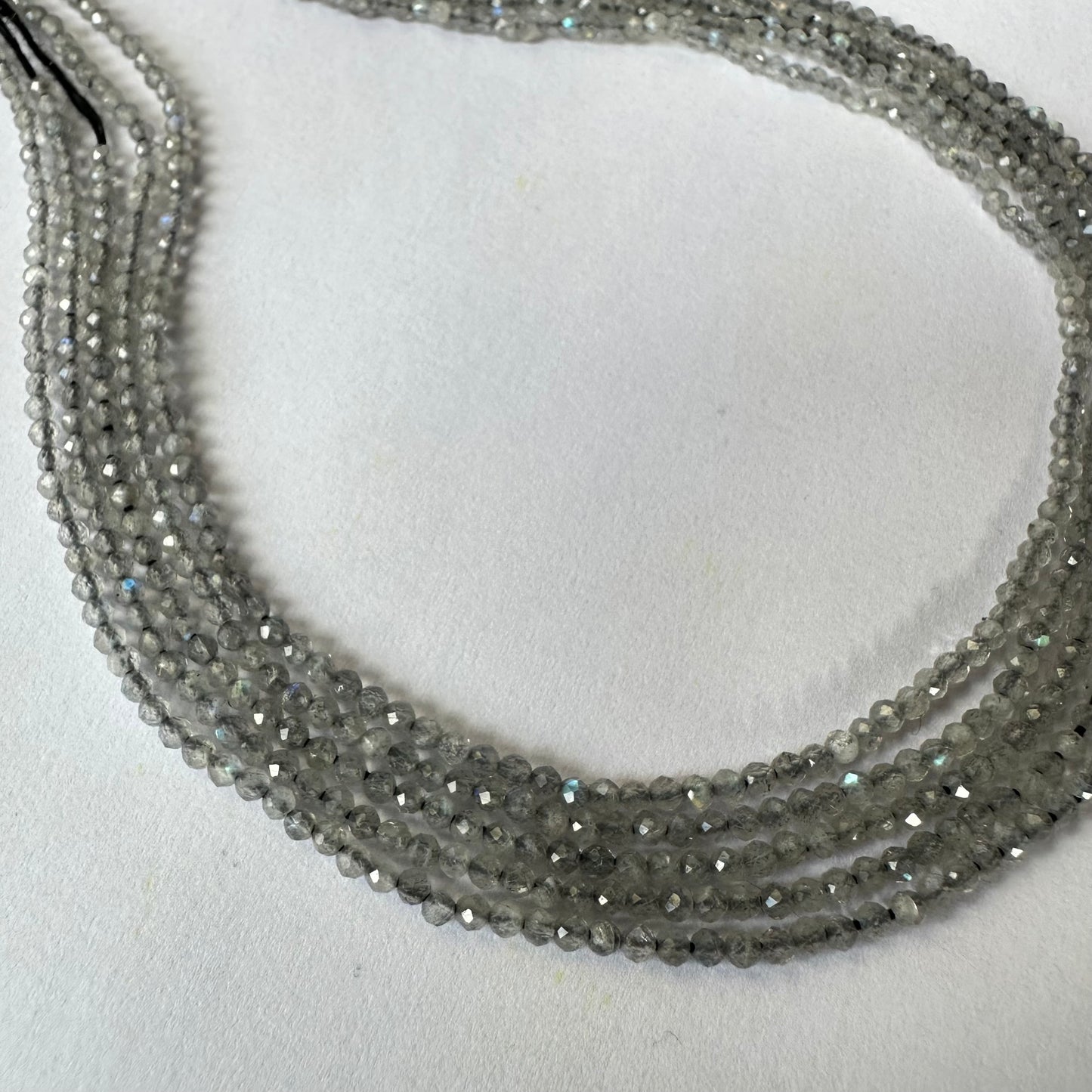 Labradorite rondelle beads sparkle under soft lighting, revealing their ethereal colour play.