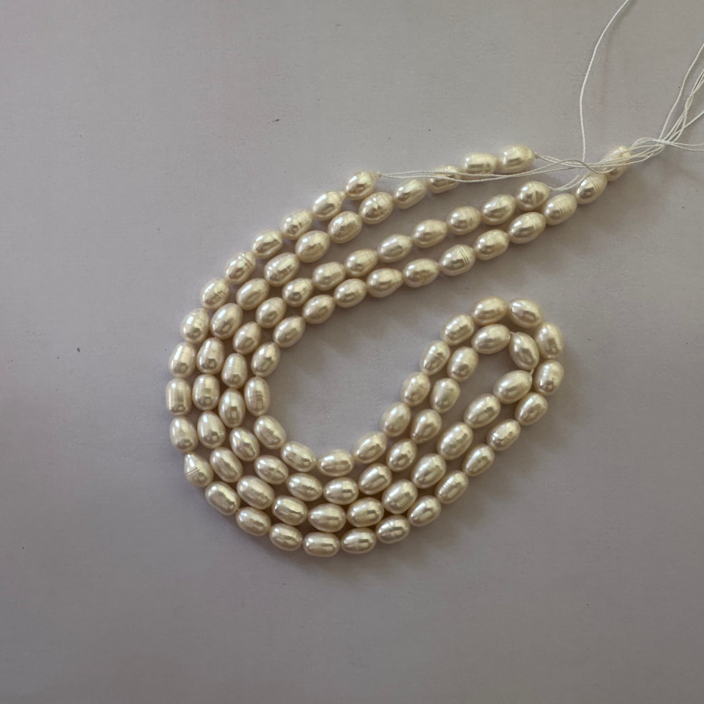 Softly lustrous Freshwater Pearls with organic texture aligned across beading thread