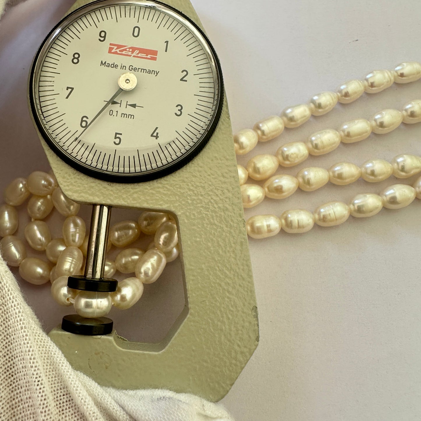 A dial gauge measures the Freshwater Pearl textured oval 8.6 x 6.2mm gemstone.