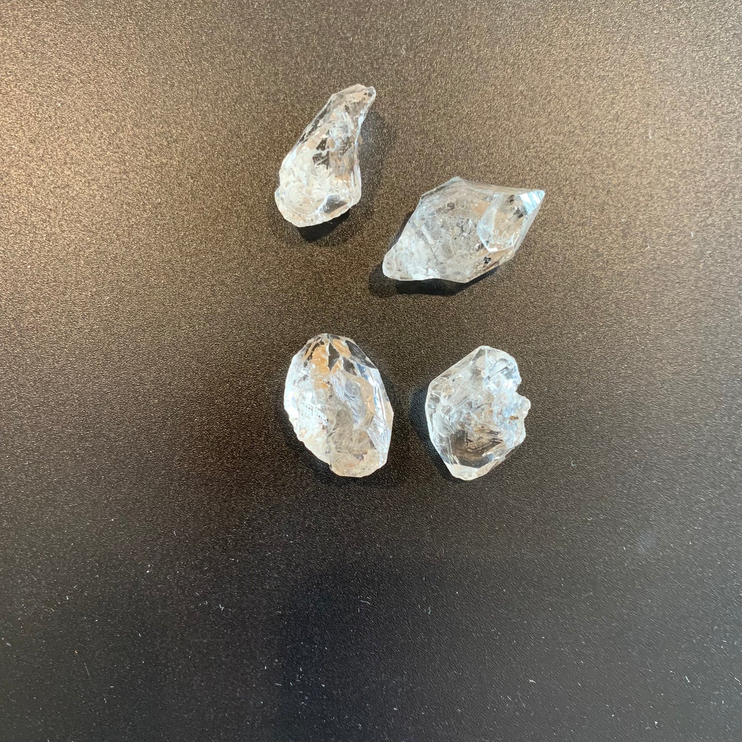 Herkimer Diamond rough gemstones glisten under soft lighting, displaying their unique raw brilliance.