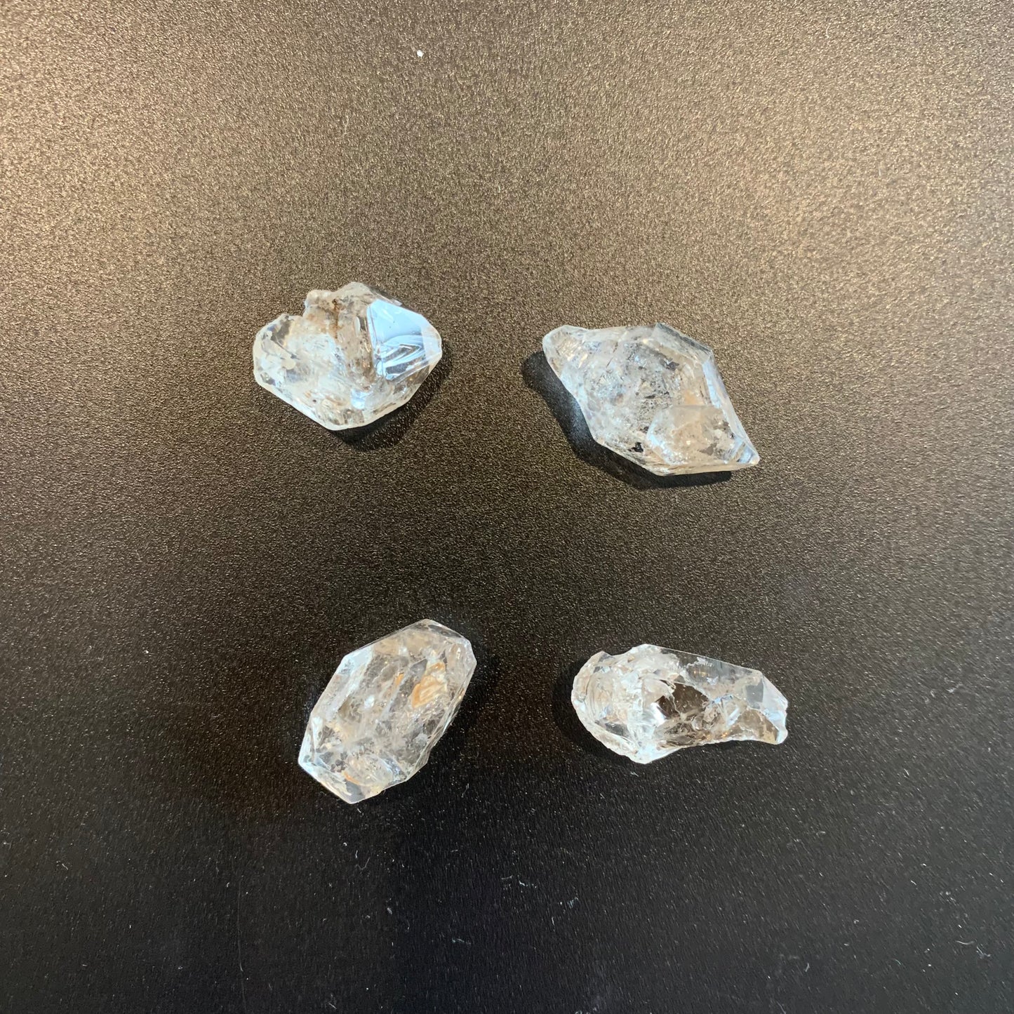 A jewellery artisan arranges Herkimer Diamond specimens, preparing them for wire wrapping or display.