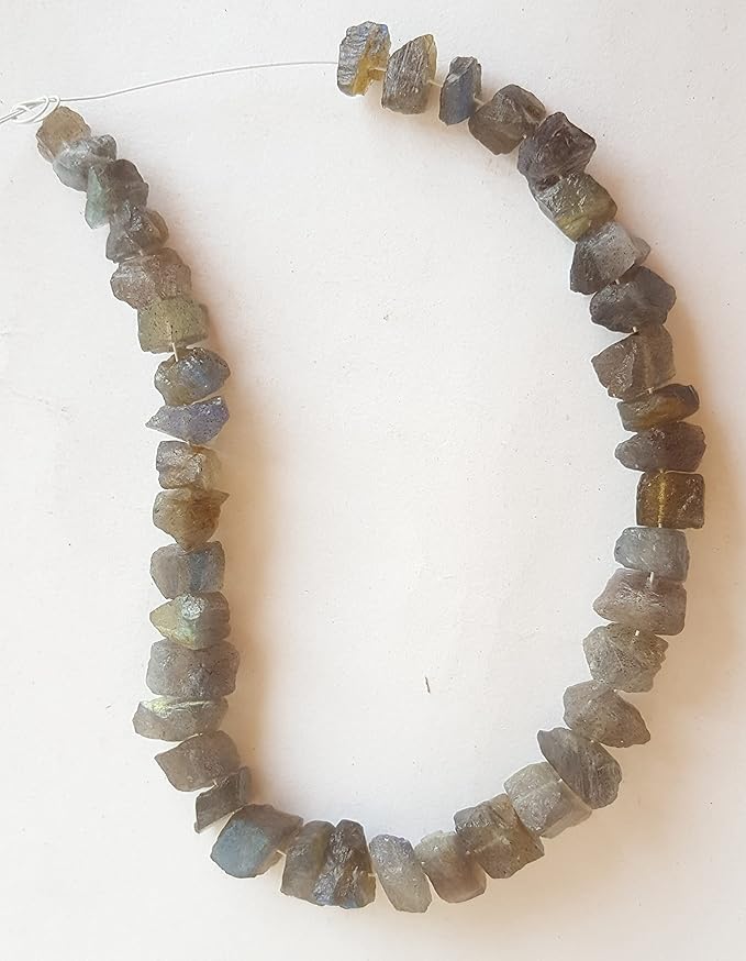 A strand of rough centre-drilled labradorite beads, highlighting their captivating yellow and brown tones in a natural arrangement.