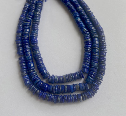 Close-up of polished Lapis Lazuli beads showcasing a smooth wheel cut and deep blue tone.