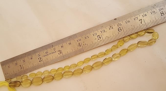 A measuring ruler next to vibrant lemon quartz stand in focus.