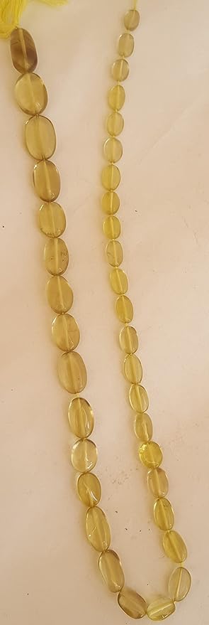 Close-up of a gemstone bead strand highlighting smooth oval lemon quartz gemstones.