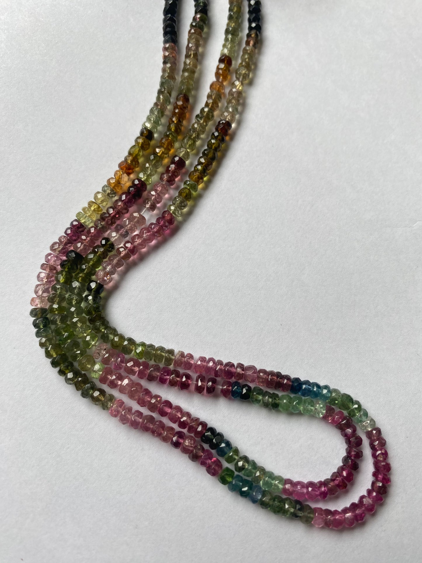 Multi-strands made of 3.5mm micro-cut tourmaline beads, displaying a stunning array of colours and textures.