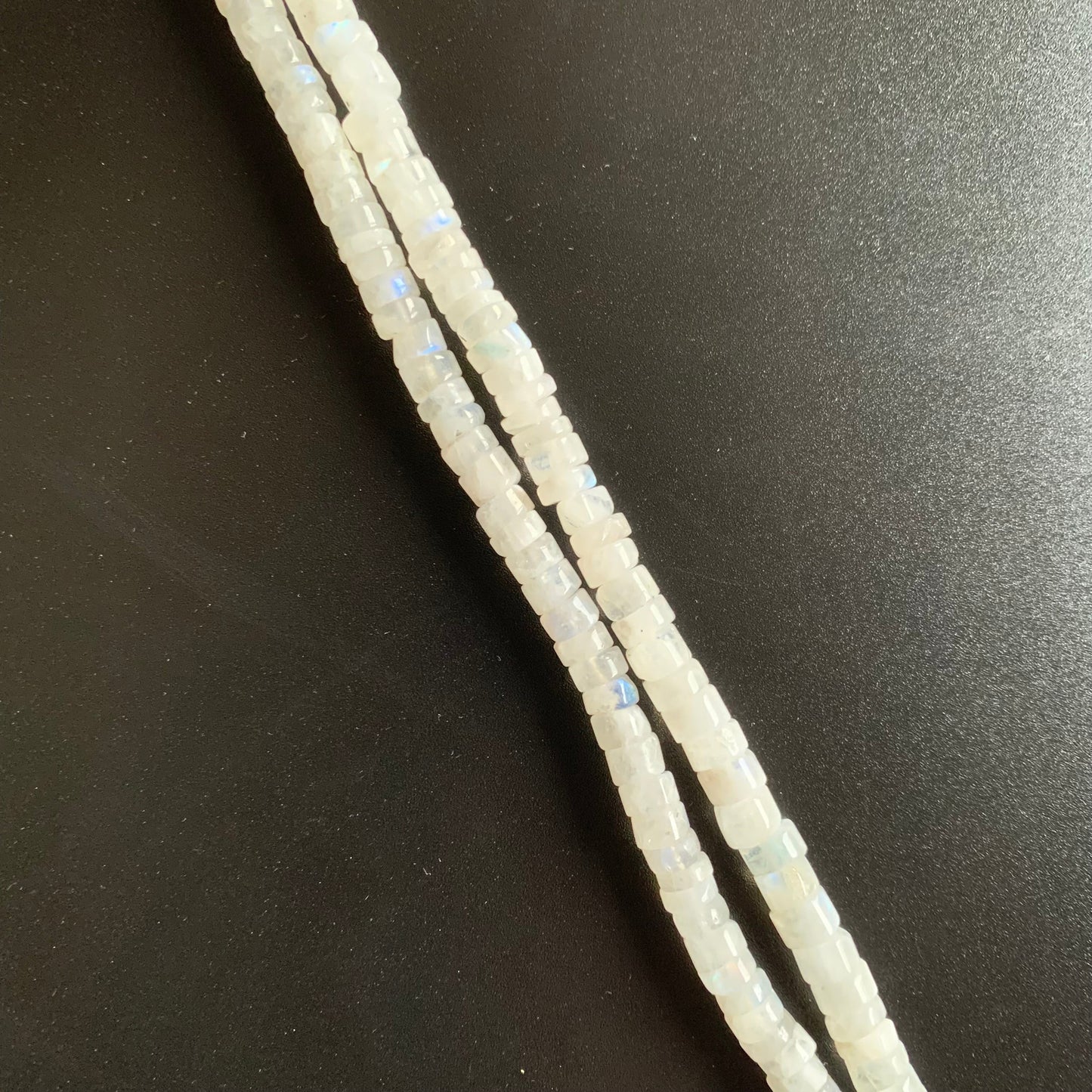 Rows of Moonstone gemstone beads, showcasing their uniform quality and smooth texture.