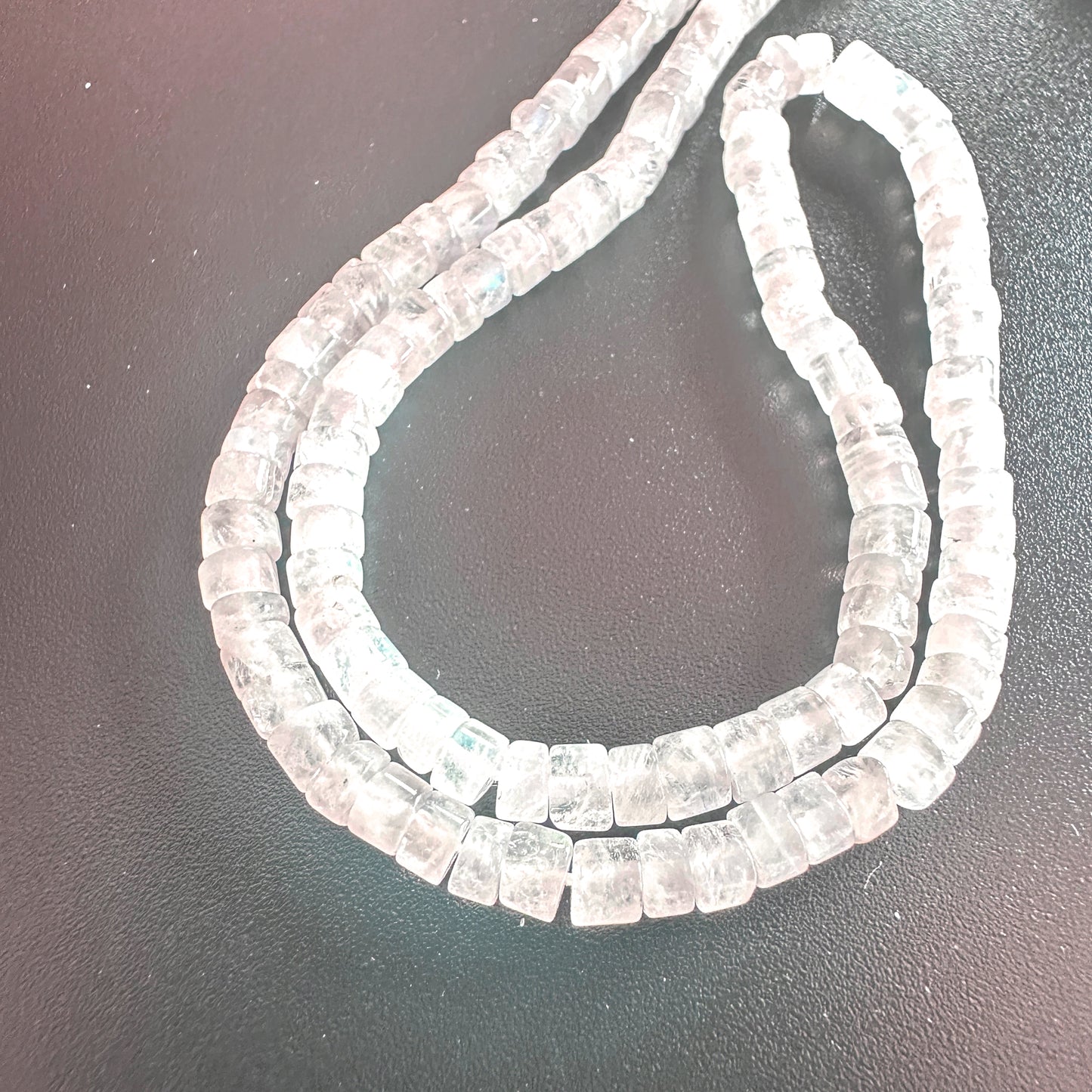 Close-up of 3.8-4mm Moonstone beads showing polished wheel cut and luminous colour.
