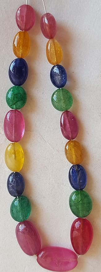 A colourful strand made of faceted rondelle beads in ruby, blue sapphire, yellow sapphire, and emerald against a white backdrop.
