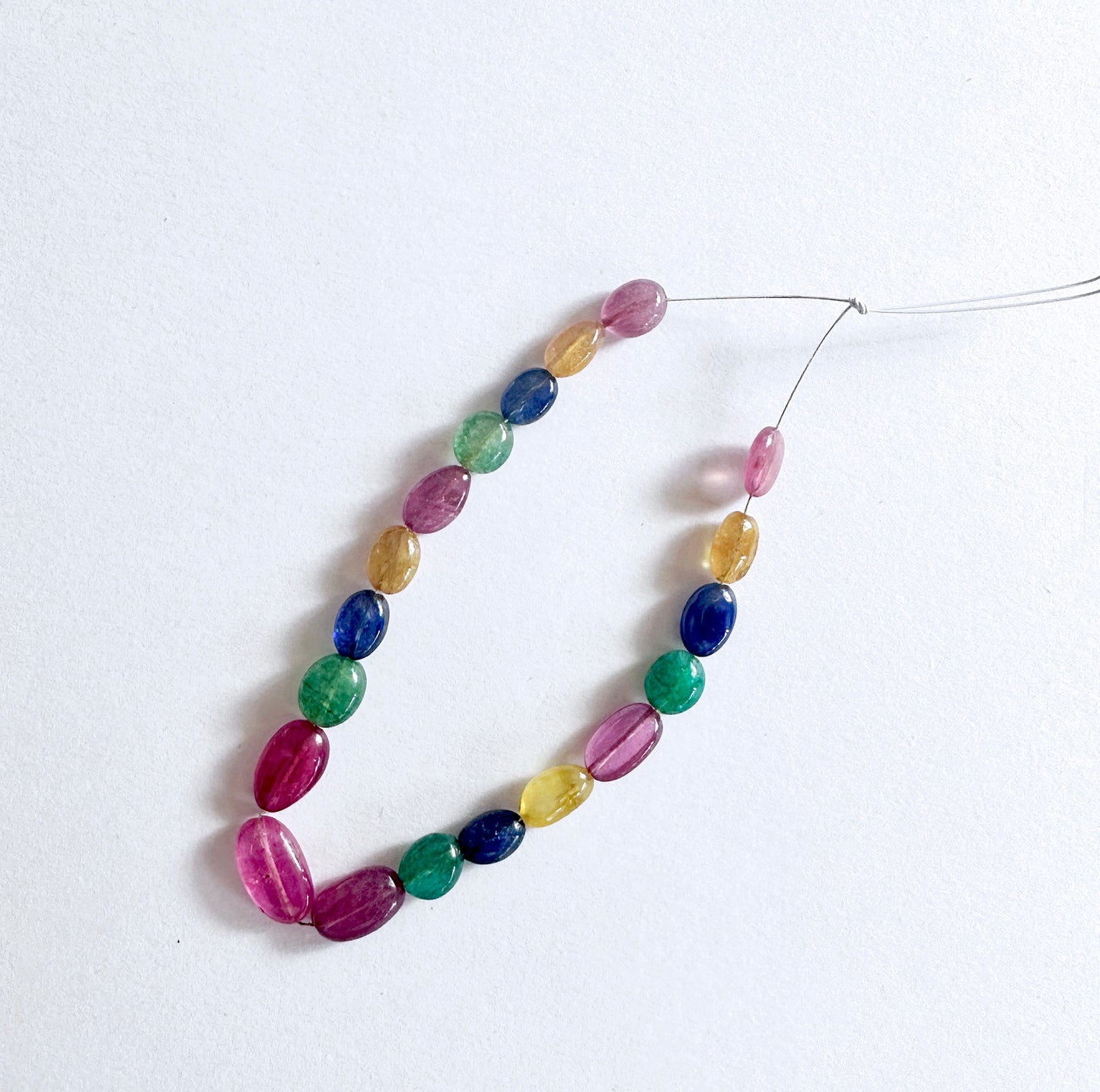 Premium multi precious gemstone beads with smooth oval cut and consistent sizing across the strand.