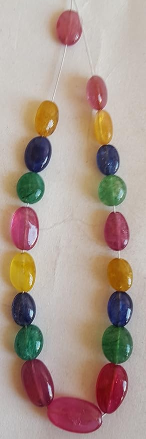 A vibrant multi-coloured strand featuring ruby, blue sapphire, yellow sapphire, and emerald beads on a white background.