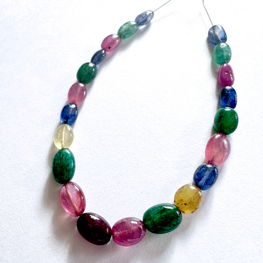 Close-up of 67 carats of multi stone oval beads with glossy finish and rich colour variation.