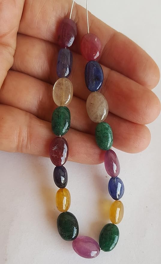A striking strand with multi-coloured beads, including ruby, blue sapphire, yellow sapphire, and emerald, set on a white background.