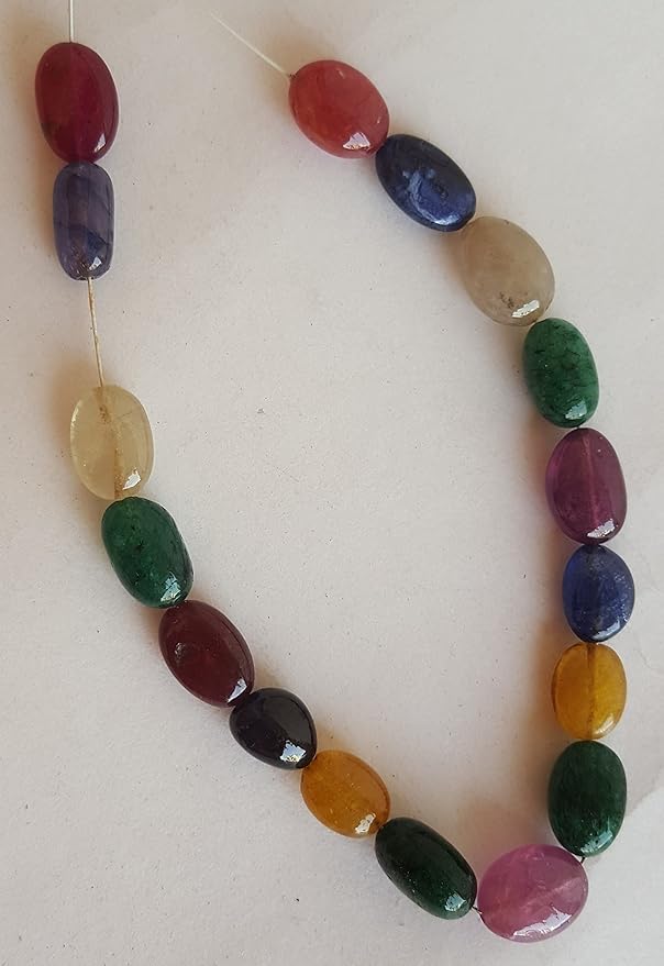 A vibrant multi-coloured strand featuring ruby, blue sapphire, yellow sapphire, and emerald beads on a white background.