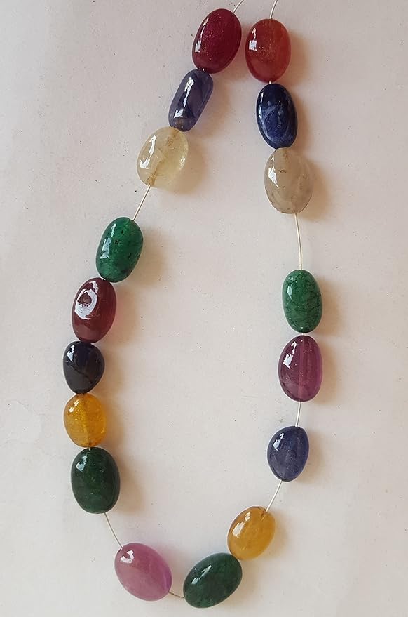 A vibrant multi-coloured strand featuring precious ruby, blue sapphire, yellow sapphire, and emerald beads on a white background.