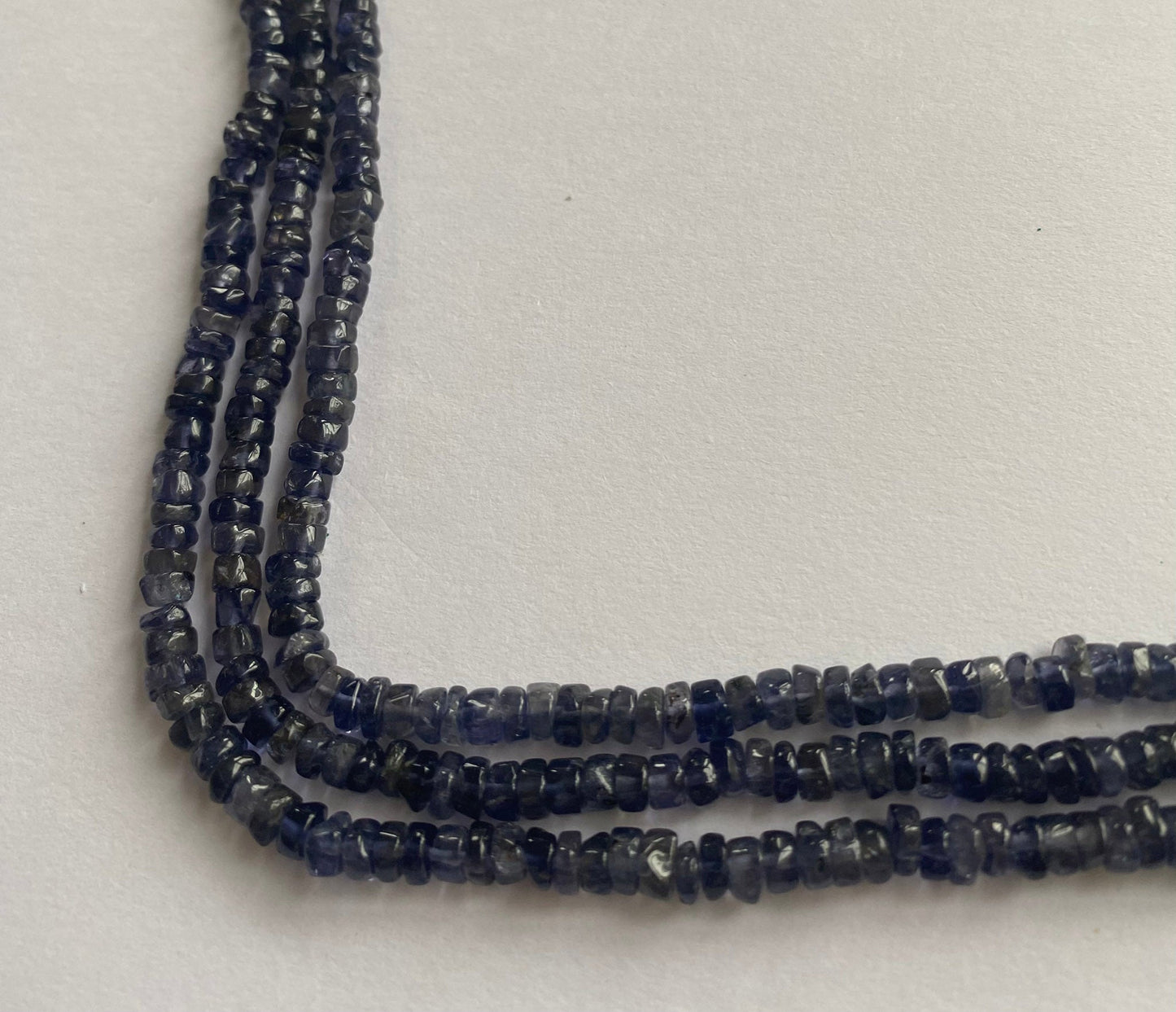 Deep blue iolite smooth wheel beads, 5 to 5mm in size, polished for a flawless finish and arranged neatly to highlight their premium quality