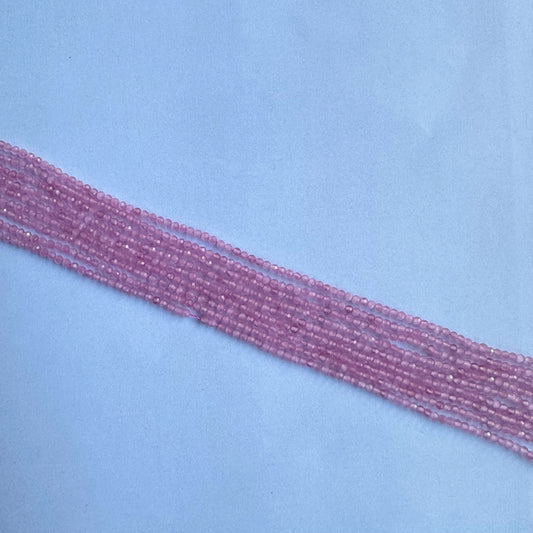 Elegant strands of faceted pink quartz beads, 2.5mm in size shown on a light background.