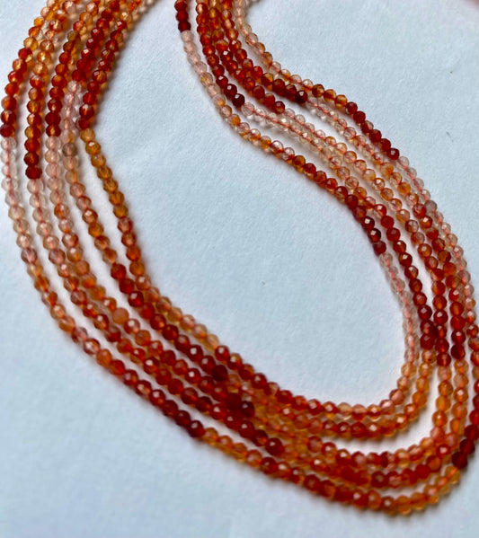 2.2mm Carnelian faceted beads for jewellery making, glowing in natural light against white background.
