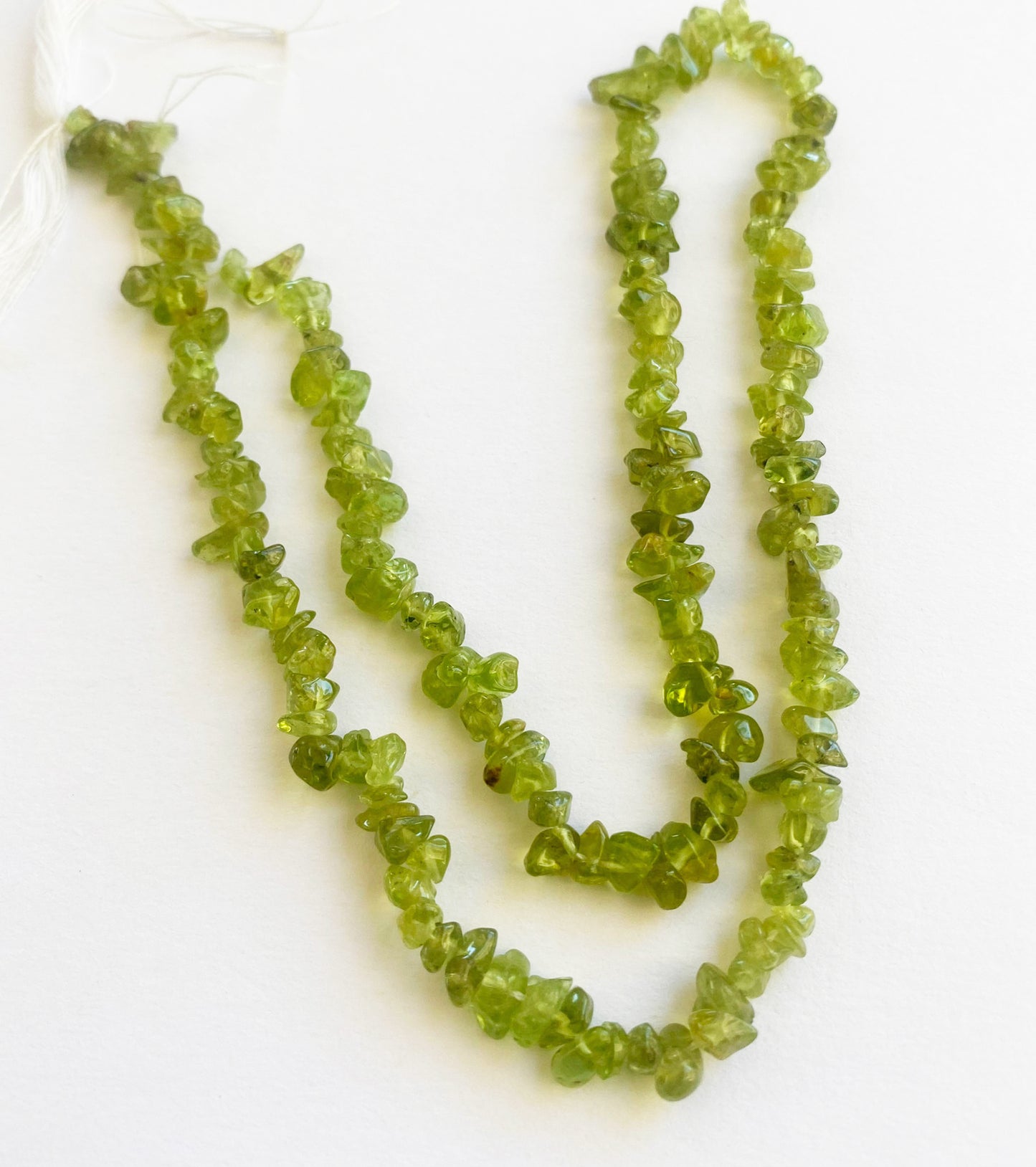 Exquisite Peridot chip beads 5 to 8mm arranged in a 45cm strand highlighting their bright green hues and organic gemstone beauty.