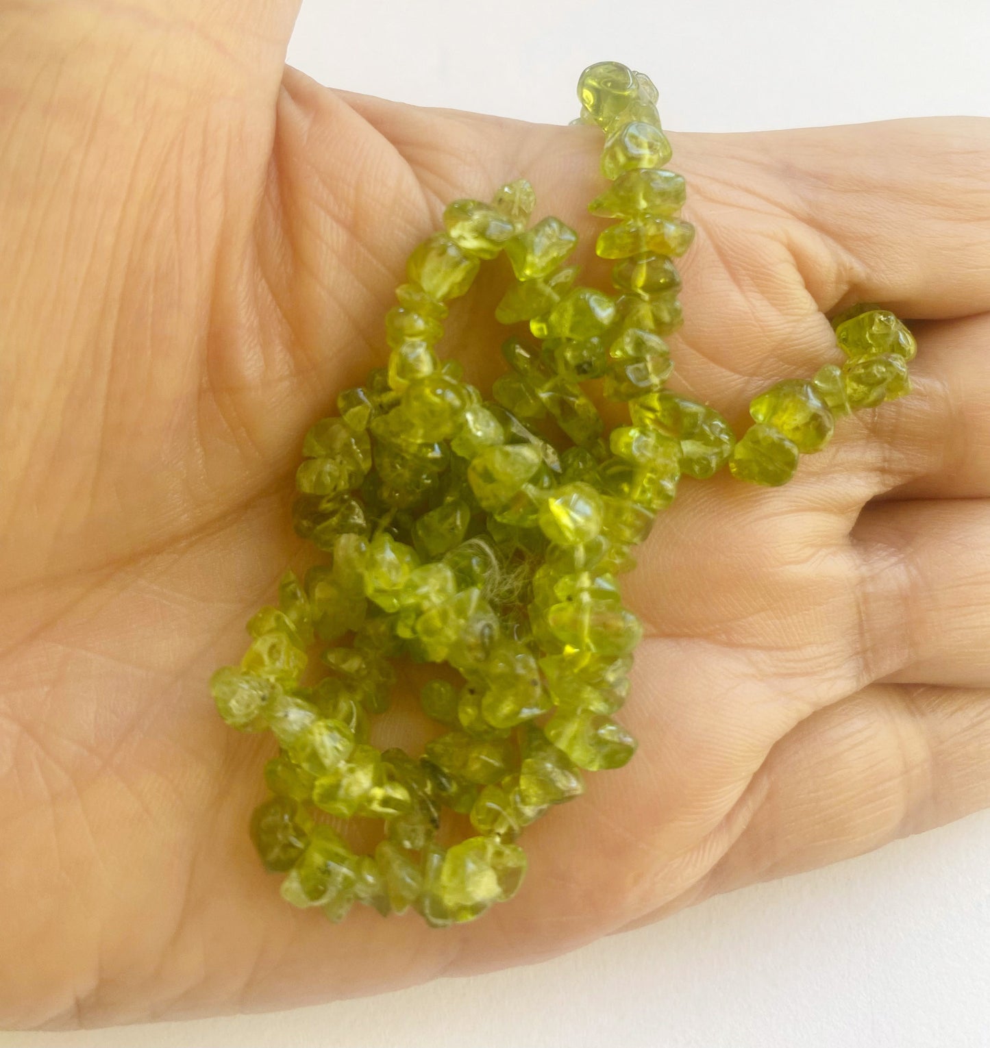 Beautiful Peridot gemstone chips 5 to 8mm showcasing a blend of fresh green hues and smooth textures ideal for artisan jewellery making.