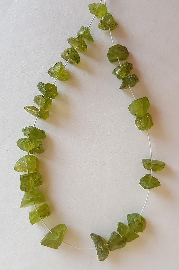 Strands featuring green peridot gemstones, each bead measuring 7mm to 8.5mm, showcasing a rough, natural texture.