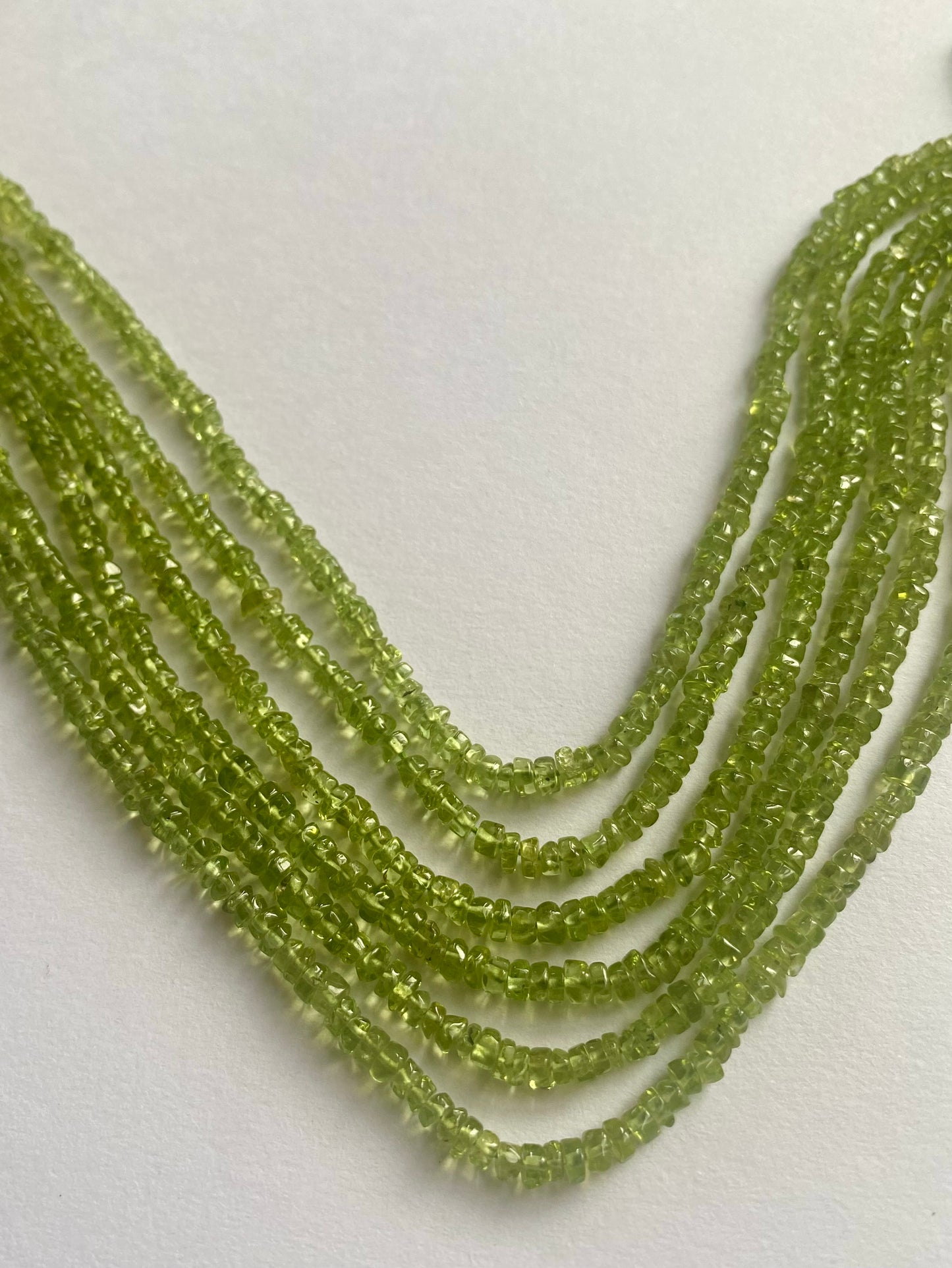 Beautiful strands of smooth green peridot beads, 3.5mm to 4mm in size, radiating a fresh and lively appearance.
