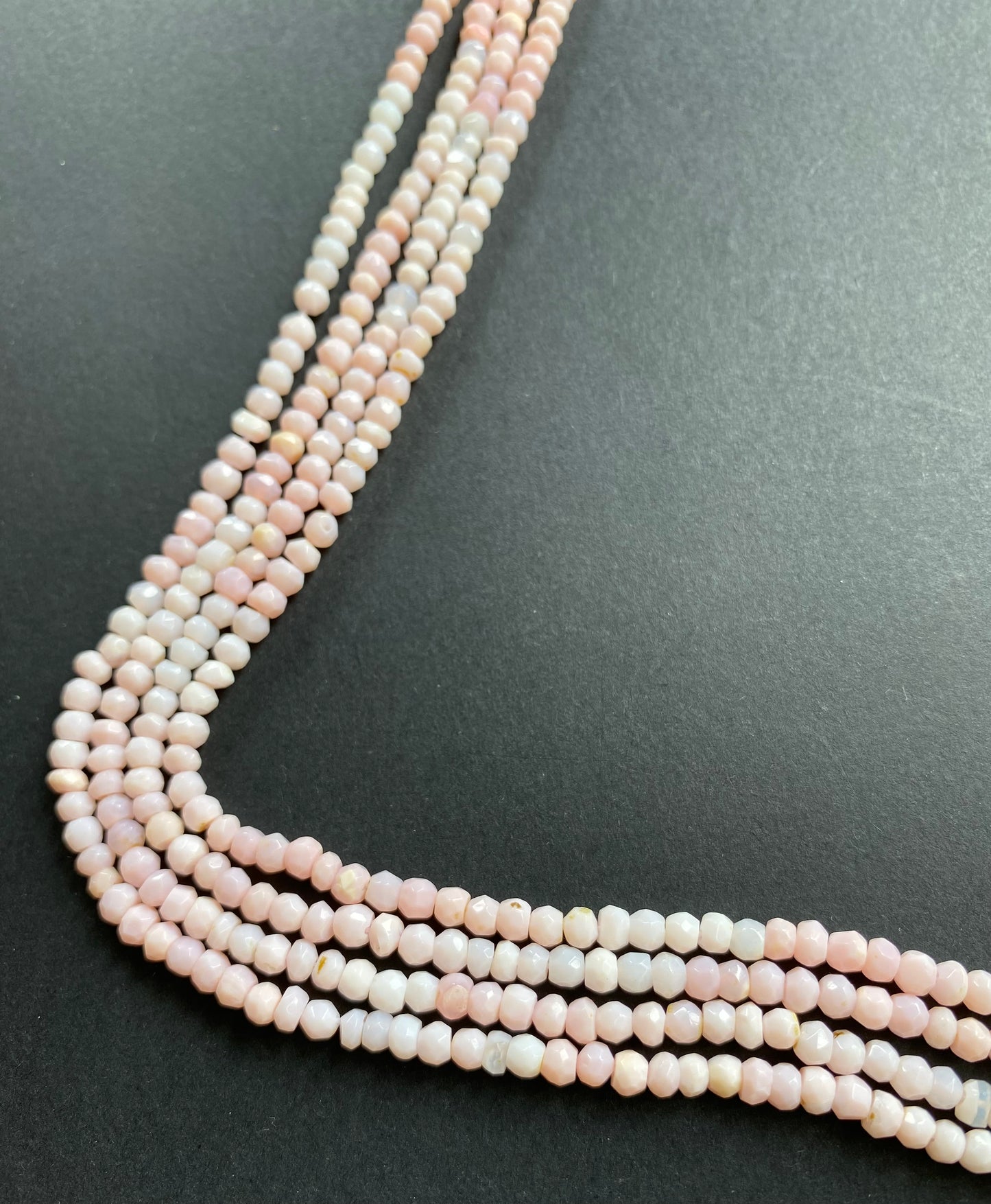 A strand of faceted Opal rondelle gemstone beads, measuring 3.5mm-4mm, showcasing their vibrant colour and shine.