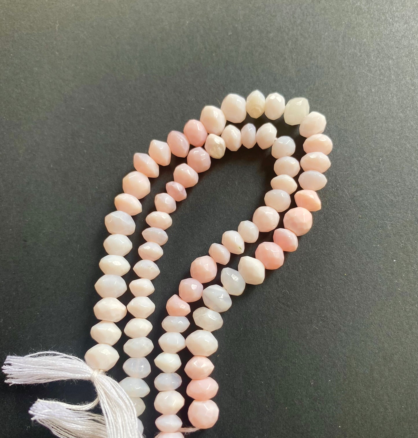 A strand of faceted rondelle opal gemstone beads, measuring 6mm to 7mm, showcasing their vibrant colour and shine.