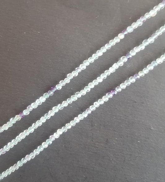 Vibrant strands of 2mm green and purple prehnite faceted rondelle beads, highlighting their natural elegance and charm.