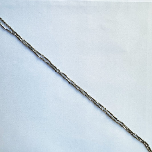 Close-up of Pyrite gemstone beads reveals their refined faceting and rich golden sheen.