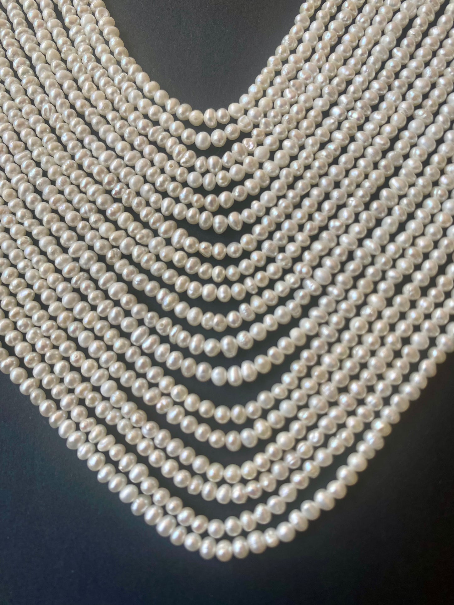 A close-up of a strands featuring numerous Rondelle Freshwater Pearls, highlighting their smooth texture and shine.