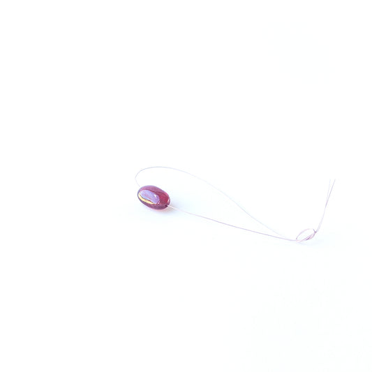 Genuine Ruby stone bead showcasing its smooth tumble shape and rich crimson tone.