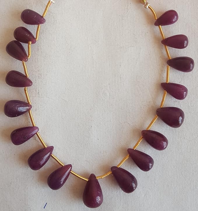 A stunning red ruby beads, elegantly hung from a delicate gold tassel.