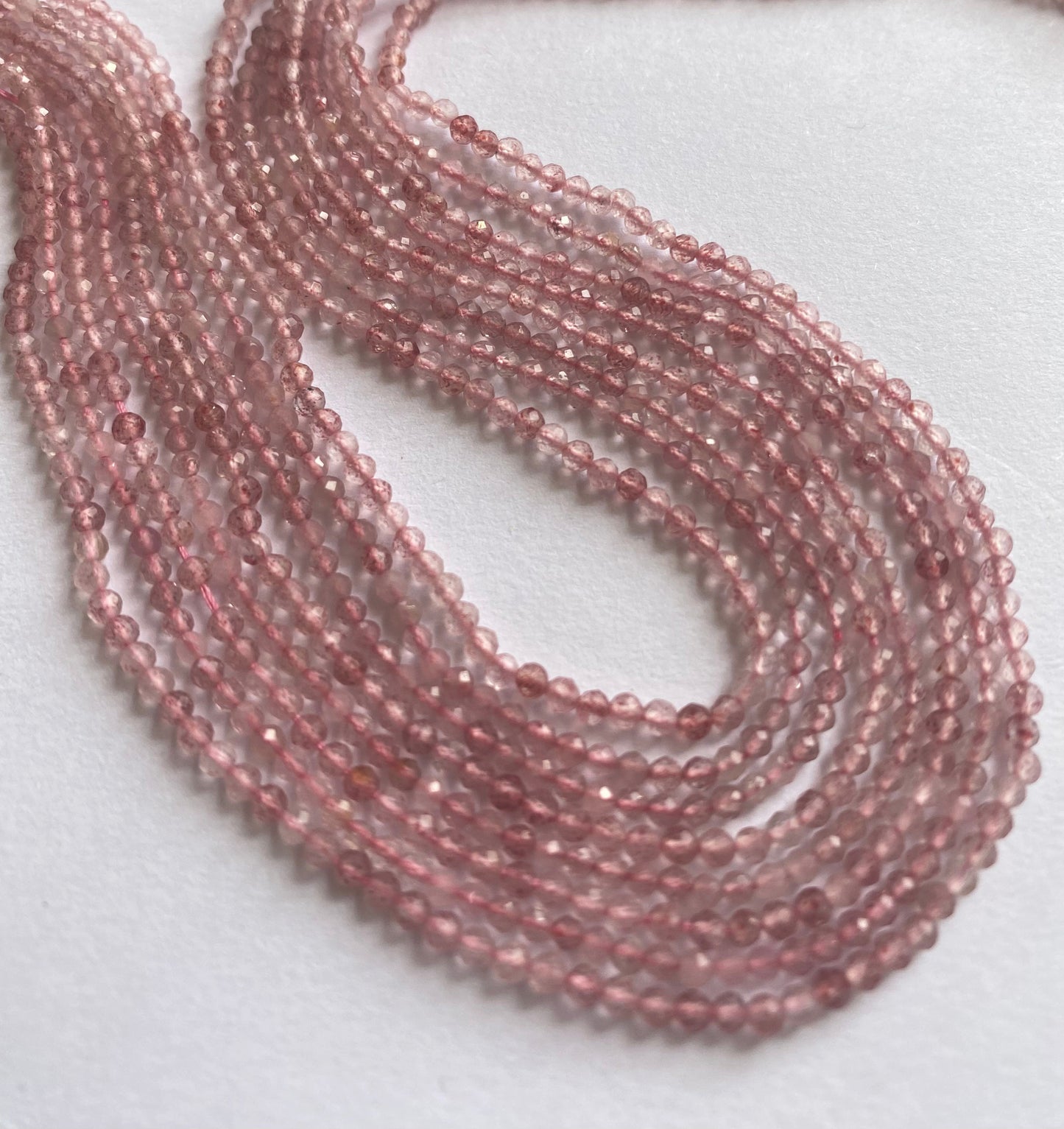 Close-up of Strawberry Quartz faceted rondelle beads, highlighting their refined cut and soft blush tones.