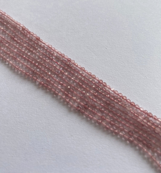 Neatly arranged Strawberry Quartz bead strands, displaying uniform faceting and exceptional gemstone clarity.