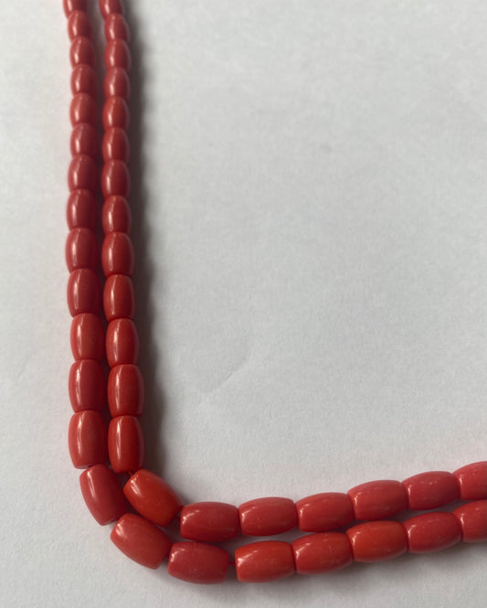 A beautiful strand of Taiwan Coral gemstone beads resting on a sleek white background, showcasing their lustre.
