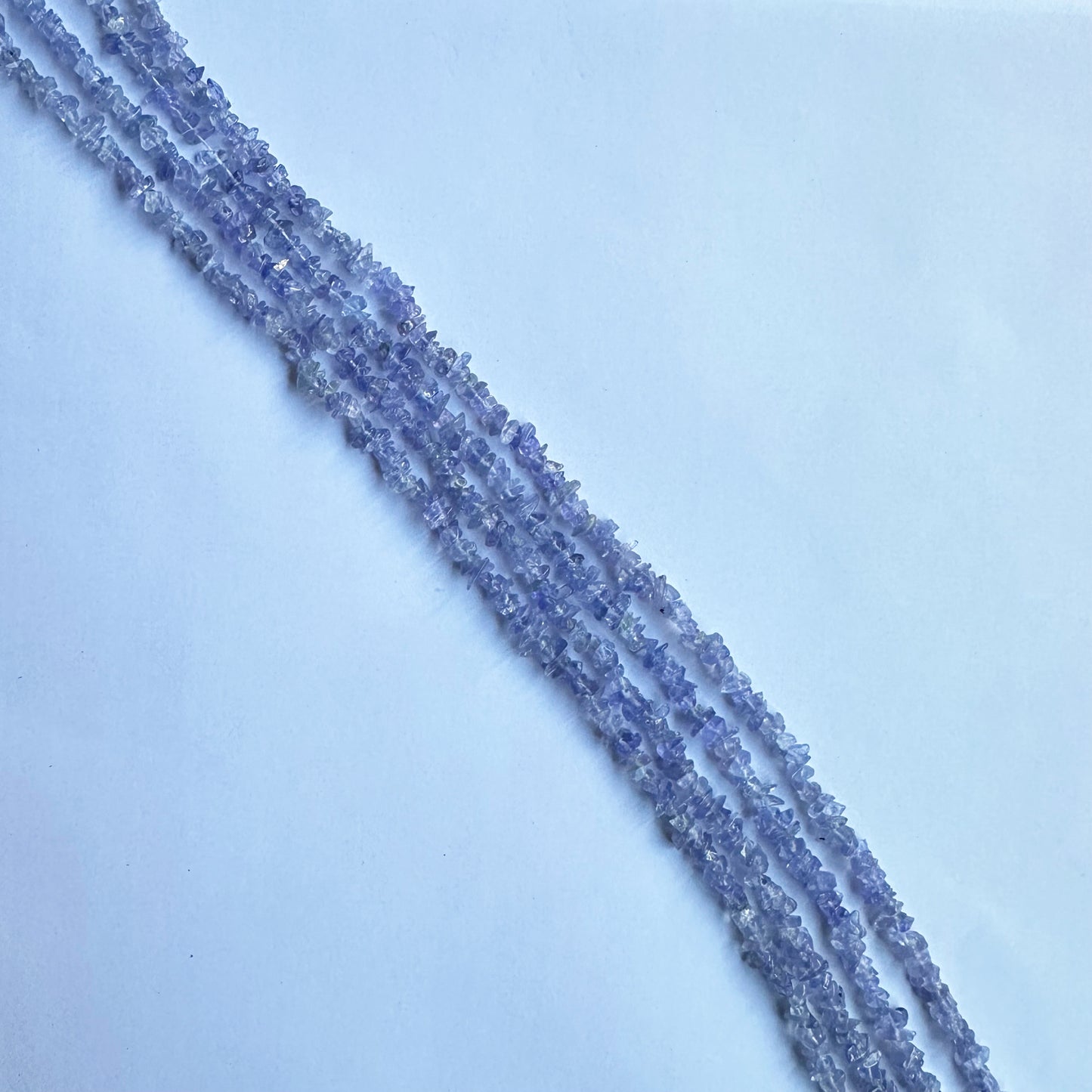 Uncut Tanzanite strands coiled together, emphasizing their deep hues and versatility in jewelry designs.
