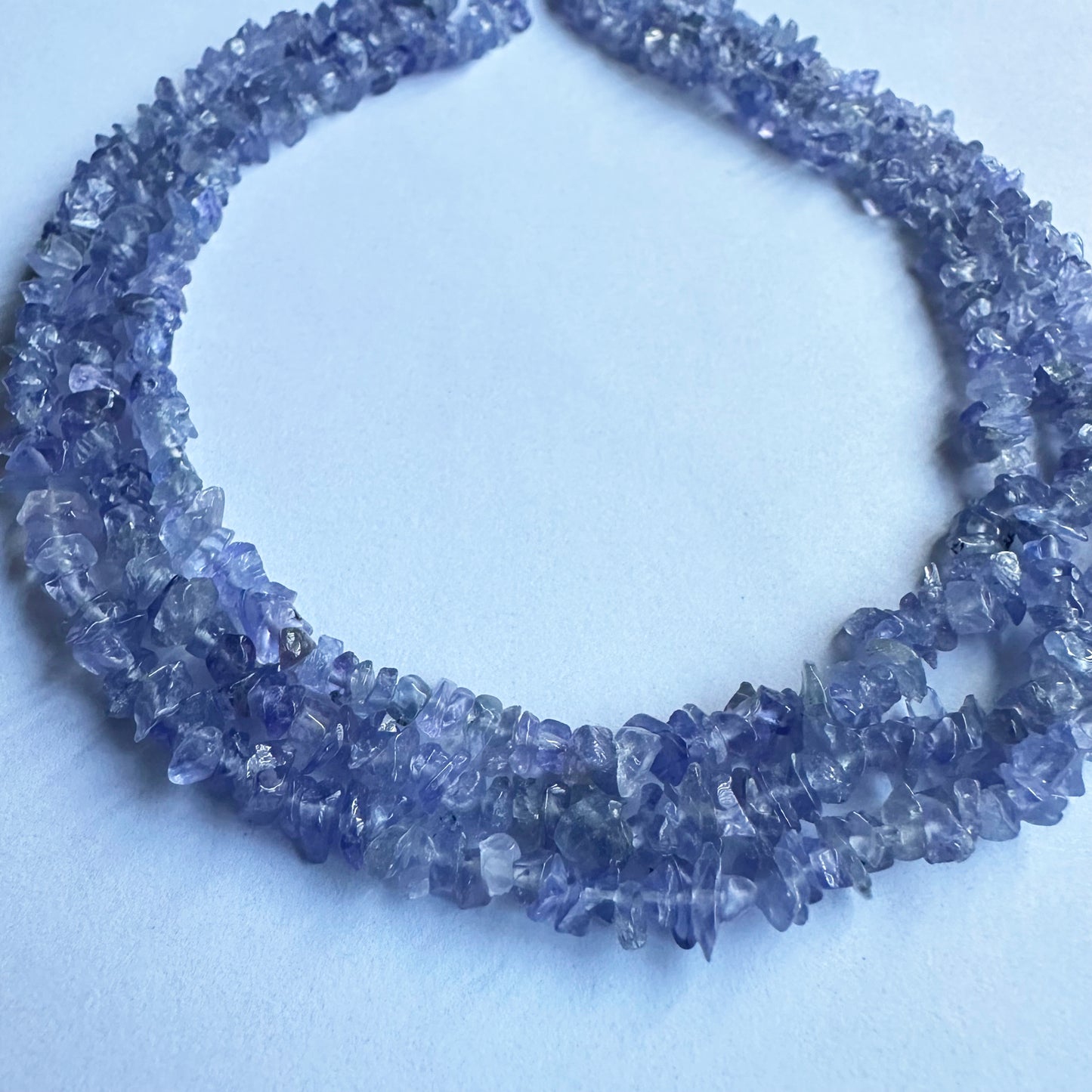 Natural Tanzanite gemstone chips glistening under light, showcasing their raw beauty and vibrant shades.