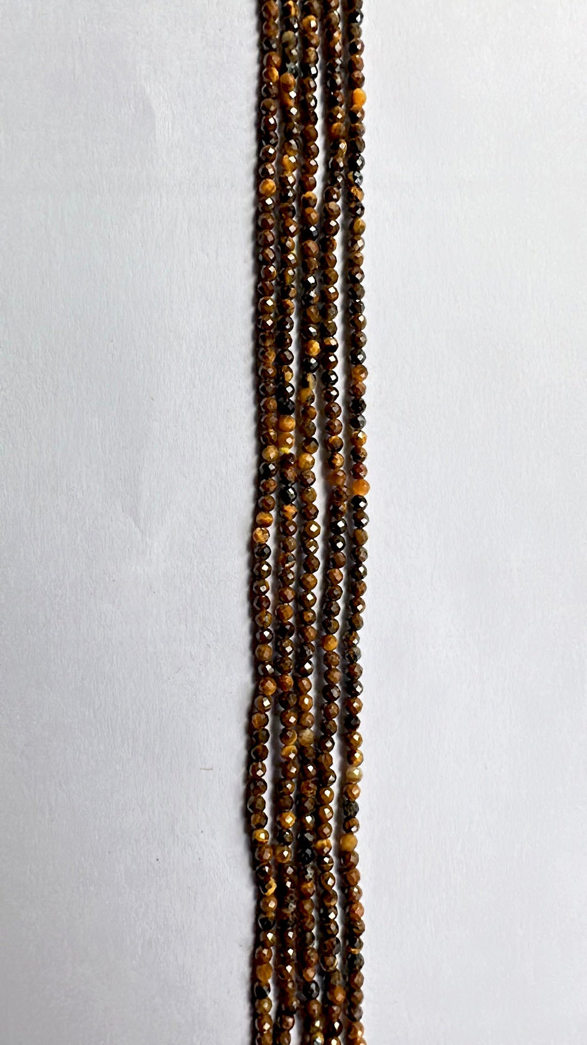 Tiger Eye micro-faceted rondelle beads in 2.2mm–2.5mm glow with warm chatoyance along a 32cm strand.