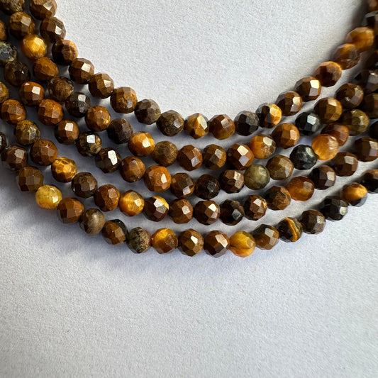 Close-up of Tiger Eye rondelle beads reveals expert faceting and vivid golden-brown colour.
