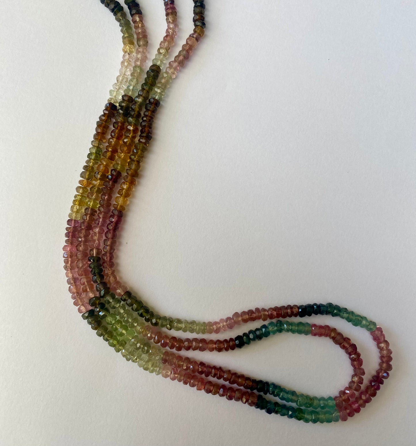 Colourful strands of tourmaline beads, measuring 3.5-3.9mm, featuring a variety of hues in a striking arrangement.
